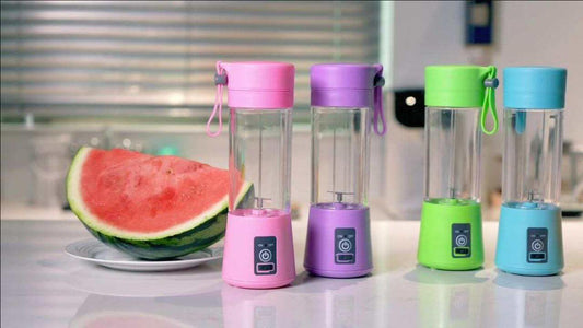 Colorful portable rechargeable blender juicers displayed with a fresh watermelon slice on a kitchen countertop.